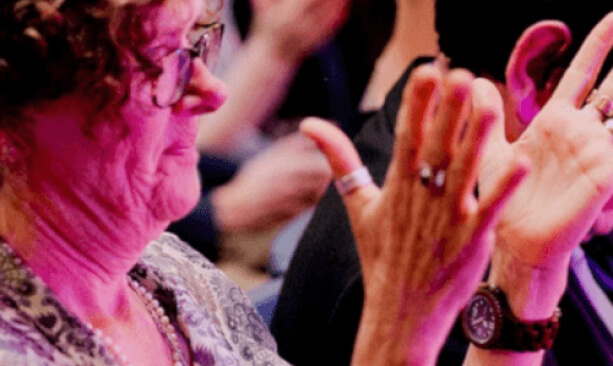 Women in audience clapping her hands